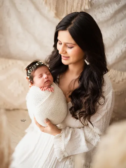 A new mother's love shines through as she holds her sleeping newborn.