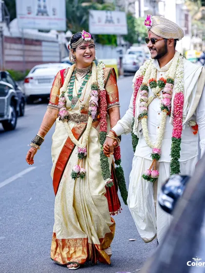 A candid street-style shot of the newly married couple, walking hand-in-hand and sharing a smile. This captures the real-world beginning of their journey.
