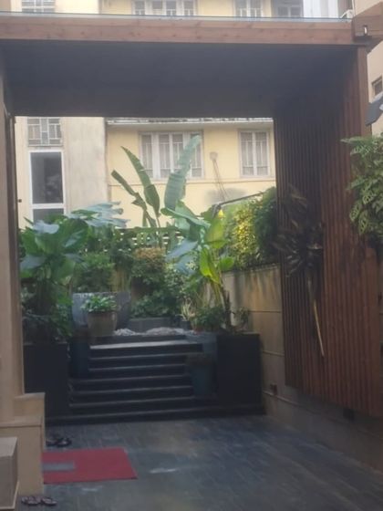 Wooden cladding used to create a warm and inviting entryway, leading into a lush garden space.