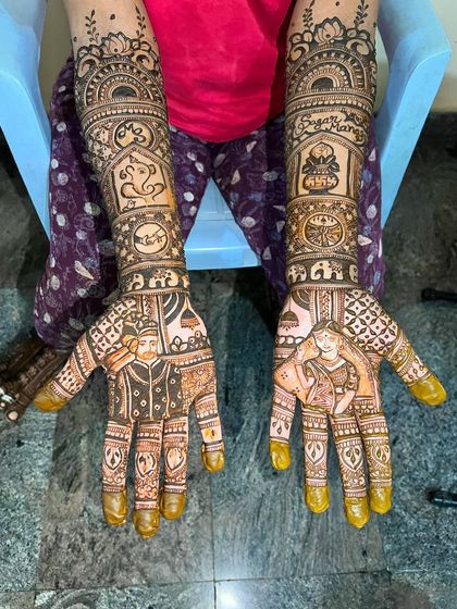 A full view of Manasa's bridal mehendi, with portraits, names, and auspicious symbols telling her story.