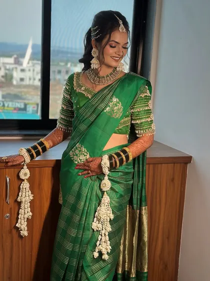 A beautiful shot of the bride showing off her fresh floral kalire. These are made from delicate white flowers and add a traditional touch to her Haldi look.