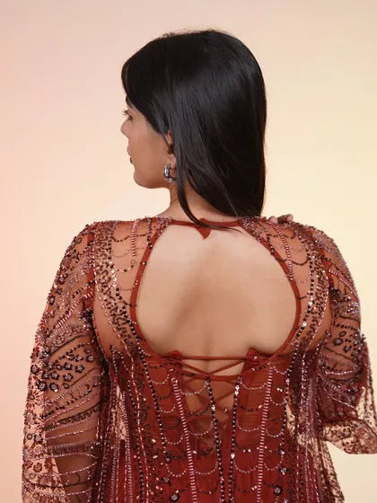 The back of this rust-colored Indo-Western outfit features a stunning keyhole detail and corset-style lacing.