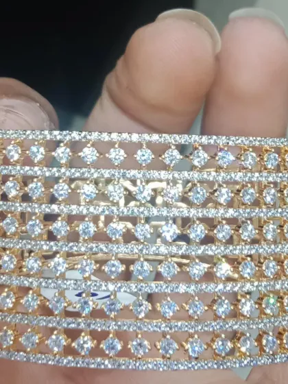 A wide American Diamond bracelet with a gold polish. The intricate lattice design gives it a very rich and luxurious feel.