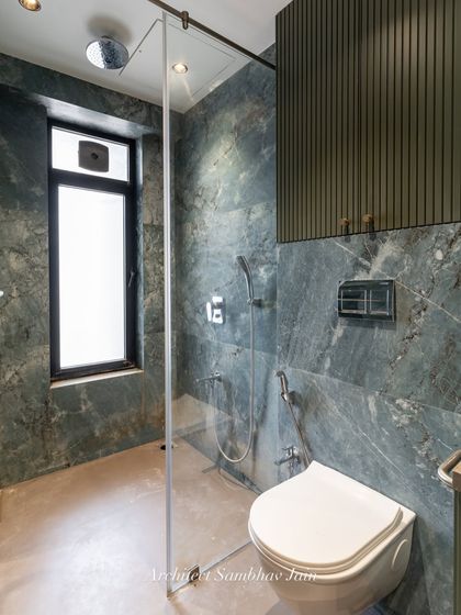 A calming blend of sage green and beige sets the tone for this timeless bathroom. The tiled shelves seamlessly merge into the walls, a conscious choice to maintain visual continuity and avoid cluttered lines.