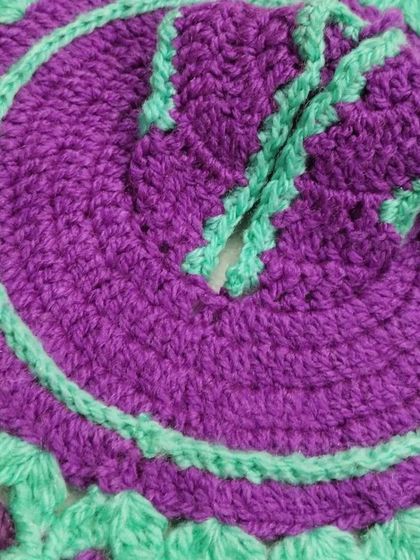 A close-up of a two-toned woolen dress in purple and mint green. The simple, clean design is perfect for daily winter wear for your Laddu Gopal.
