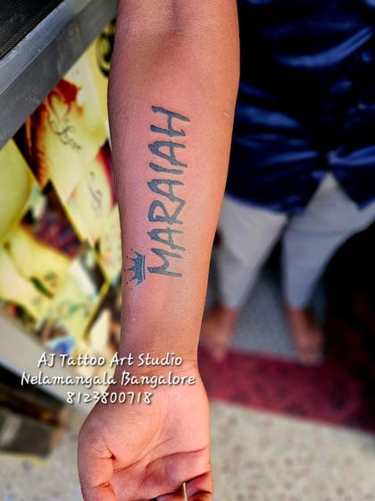A "MARAIAH" name tattoo with a small crown, done in a strong block font.