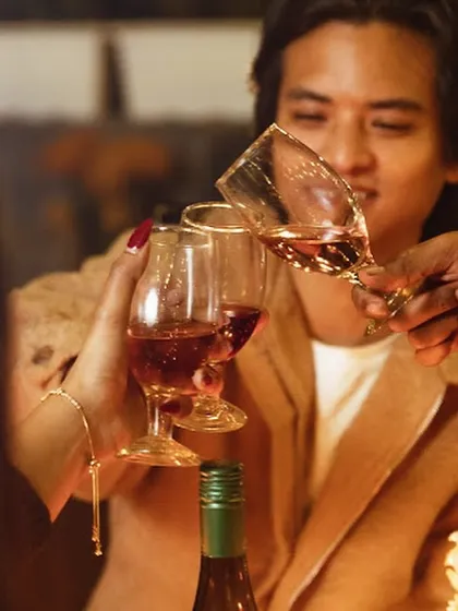 A toast to good times. This close-up shot captures the clinking of glasses, a symbol of the connection and celebration that happens at our intimate gatherings.