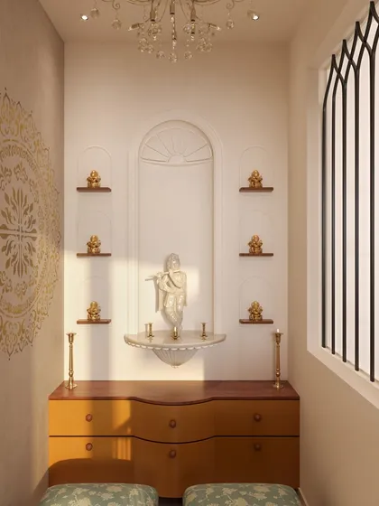 Inside the puja room, the mandir is designed with an arched niche that mirrors the entryway. Small shelves hold brass idols, and a beautiful mandala stencil on the wall adds a spiritual and artistic element.
