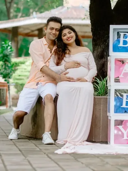 A cute maternity shoot portrait with 'BABY' blocks, hinting at the gender with blue and pink balloons inside.