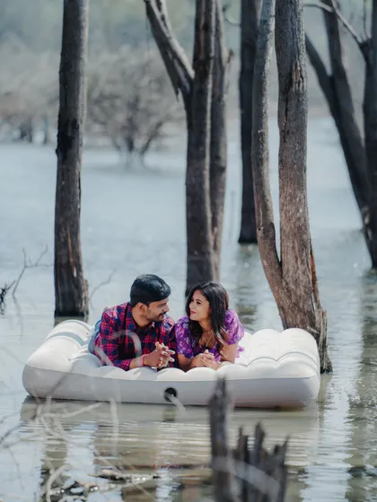 This couple is enjoying a quiet, intimate moment on the water. The floating mattress concept creates such a unique and serene pre-wedding photo.