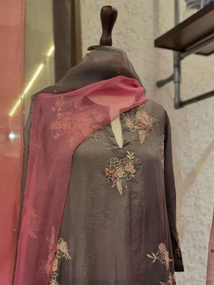 A beautiful kurta from Kora's new collection. The charcoal grey silk is adorned with delicate pink floral embroidery and paired with a matching sheer dupatta.