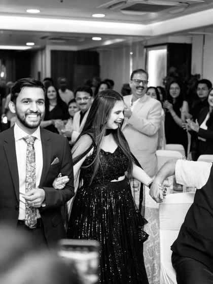 The bride and groom make their entrance at the cocktail party, greeted by the applause and happy faces of their family and friends.