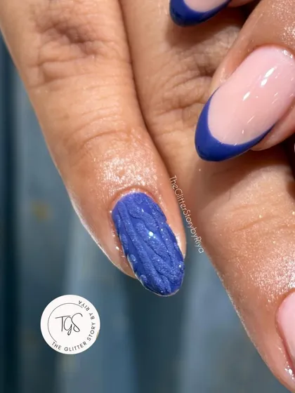 A close-up of a cozy "sweater nail" design, featuring a 3D cable-knit texture in a vibrant blue, perfect for winter.