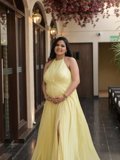 A full-length shot of this glowing mommy-to-be. The makeup is soft and subtle, with a focus on a peachy blush, soft brown eyes, and lots of highlighter to enhance her charm.