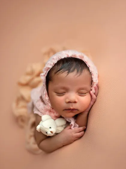 Adding a little bonnet and a tiny teddy bear adds another layer of cuteness to this simple beanbag pose.