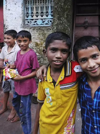 A group of friends poses for the camera in a colorful alley. Their camaraderie and youthful energy bring a sense of vibrancy and hope to the street portrait.