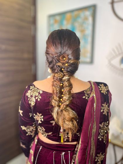 A beautiful fishtail braid with golden bead embellishments. This hairstyle is perfect for a guest who wants an elegant yet intricate look.