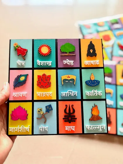A clear, straight-on view of the hand-held Marathi month calendar, showing the detail of each icon.