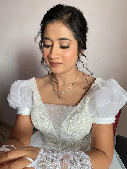 The bride looks down, showcasing the soft, neutral eyeshadow and delicate lashes.
