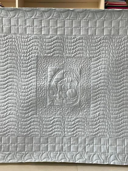 The back of the Mario quilt, where you can see the traced outline of Mario and the different quilting textures.