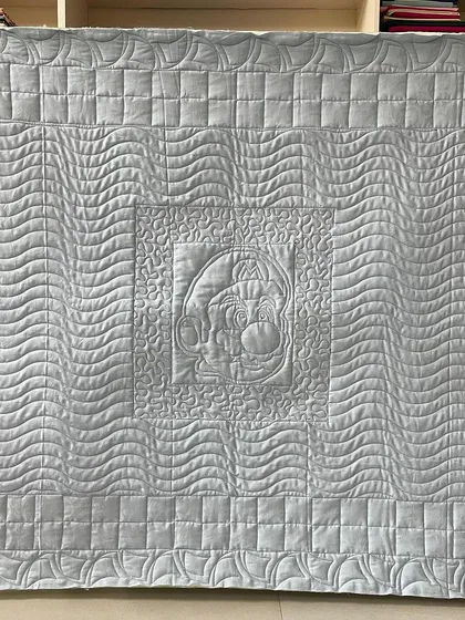 The back of the Mario quilt, where you can see the traced outline of Mario and the different quilting textures.