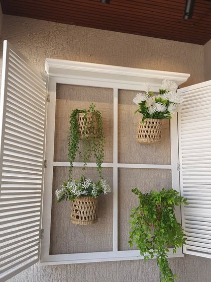 A beautiful white decorative French window installed on a balcony wall. I've styled it here with hanging jute baskets filled with artificial plants, creating a lovely, rustic focal point.