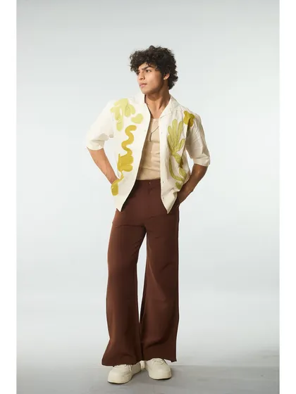 An editorial look with a unique, artistic shirt. The grooming is clean and simple, with naturally styled curls, allowing the fashion to be the hero.