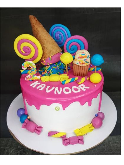 Another version of a Candyland cake, this one with a fresh pineapple flavor. The pink drip and colorful candy decorations make it a sweet treat for a second birthday.