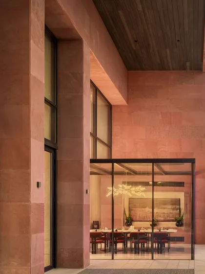 The glass-encased private dining room at the Elevate Clubhouse offers an exclusive experience while maintaining a visual connection to the outdoors. The bold, red sandstone exterior provides a powerful contrast to the transparent walls, showcasing our use of materiality to define and enhance spaces.