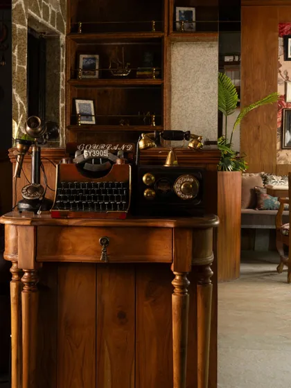 This corner is filled with handpicked vintage treasures that whisper stories of the past. A classic typewriter and rotary phone sit atop a wooden console, adding character and a sense of nostalgia.