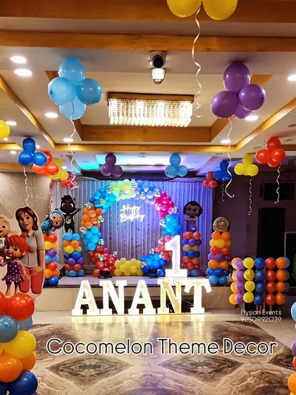 I bring popular themes to life, like this complete Cocomelon setup for a first birthday. The decoration includes large character cutouts, LED lettering for the name, a central balloon arch, and smaller balloon columns throughout the venue.