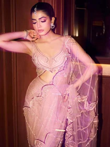 This blush pink sari exudes elegance with its soft hue and shimmering, hand-embroidered motifs, offering a perfect balance of tradition and contemporary style.