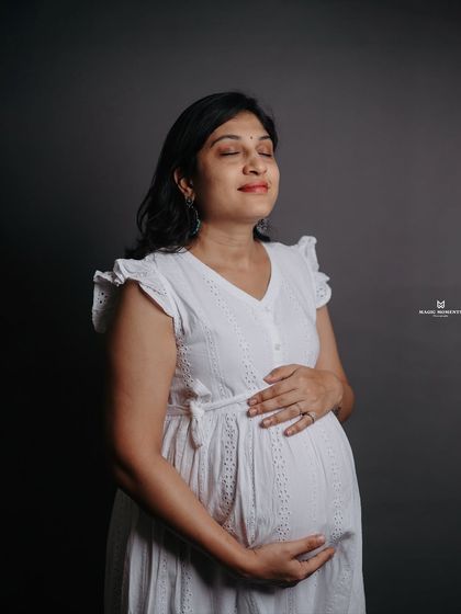 A serene and peaceful moment captured in the studio. With her eyes closed, the mother-to-be connects with her baby in this beautiful, contemplative portrait.