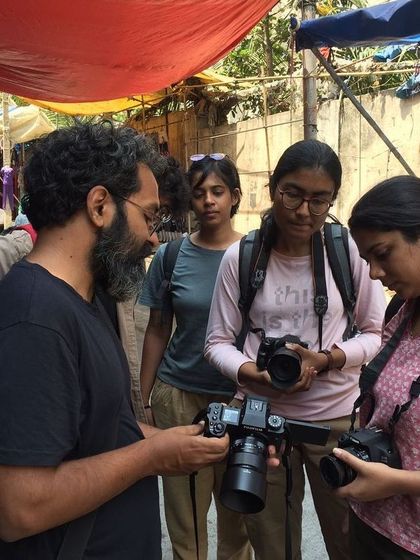 An instructor discussing camera settings with participants during a photowalk. Our workshops combine technical learning with practical, on-location experience to build your skills and confidence.