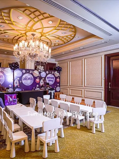 Even in a grand ballroom, our furniture creates the perfect kids' corner. This image shows our white tables and chairs set up for a space-themed birthday party, providing a dedicated and comfortable area for young guests.