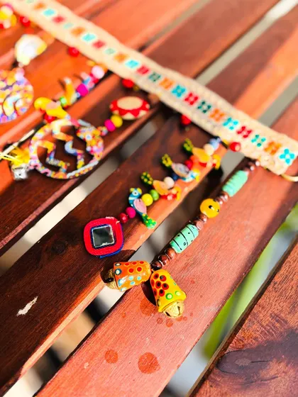 A detail shot of the 'Rang-Tarang' toran, focusing on the little painted bells and the colorful threadwork.