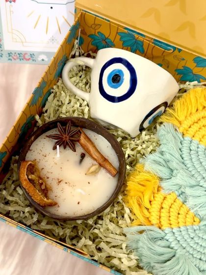 A closer look at the details in my Nurture and Protection hamper. The coconut shell candle is infused with spices like star anise and cinnamon, and the evil eye mug is handcrafted, making each piece unique.