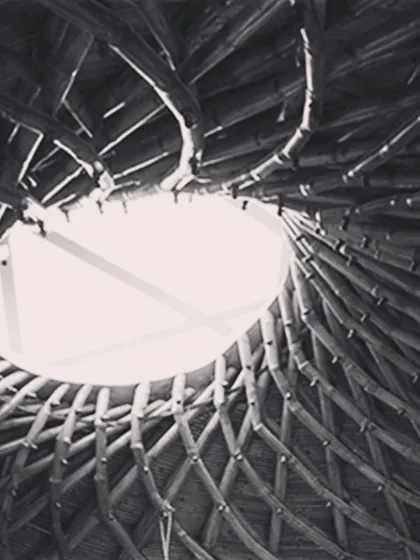 The completed roof of a yoga hall, inspired by the work of the great architect Revathi Kamath. This intricate, spiraling bamboo structure with a central skylight shows the incredible potential of bamboo as both a structural and aesthetic material in sustainable building.