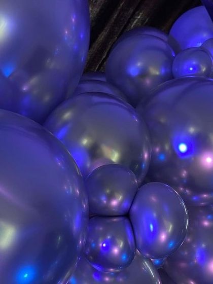 A close-up shot of the reflective silver chrome balloons, showing the cool lighting effects and modern texture of the decor.