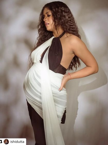 A bold and modern take on maternity fashion. This unique black and white draped gown offers a high-fashion look for your studio photoshoot, proving that pregnancy style can be chic and edgy.