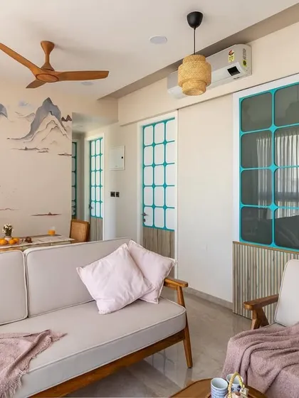 This wide shot captures the serene atmosphere of the living area, where the custom mural provides a stunning focal point that complements the minimalist wooden furniture.