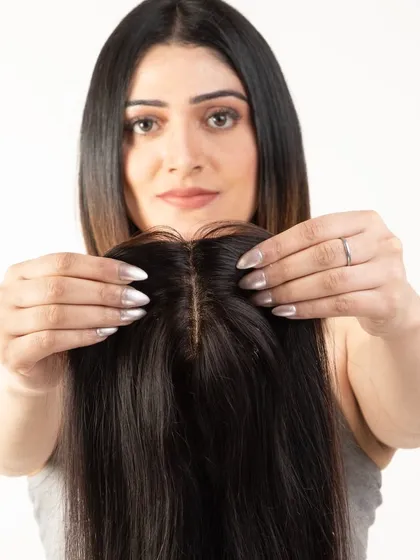 A close-up of a model showing the natural-looking scalp part of the hair topper.