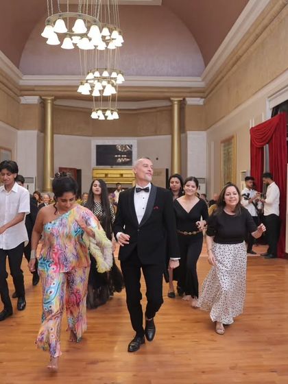 Our director leads a group in a dance at the Grand Ball. The event was not just formal but also incredibly fun and interactive for all attendees.