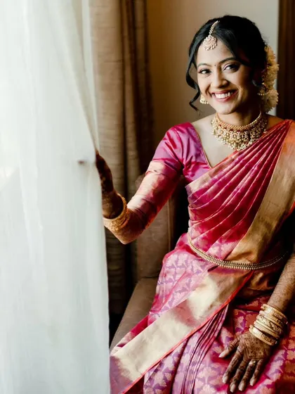 A series of photos capturing the grace of this South Indian bride. Her look features traditional temple jewelry, a silk saree, and a fresh, dewy makeup finish with a classic floral hair bun, embodying timeless elegance.