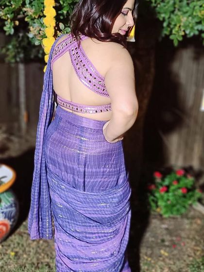 Another view of this gorgeous purple pre-draped saree, highlighting the intricate, backless design of the mirror-work blouse. It's a statement piece that's sure to turn heads.