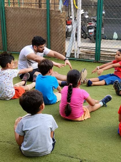We always start and end our sessions with a good stretch. Here, I'm guiding the kids through some seated stretches to improve flexibility and teach them the importance of warming up and cooling down their muscles.
