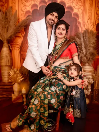 A beautiful family portrait in traditional Indian attire. The mother, father, and daughter pose together, creating a culturally rich and loving image.