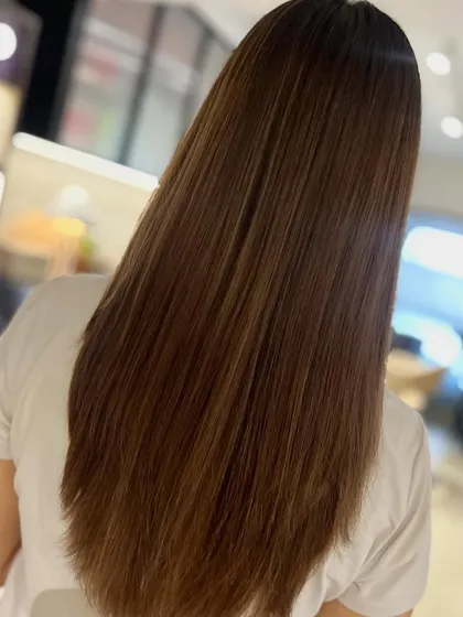 A classic face-framing layered cut paired with a two-tone highlight blend. This look, styled straight, is chic, polished, and timeless.