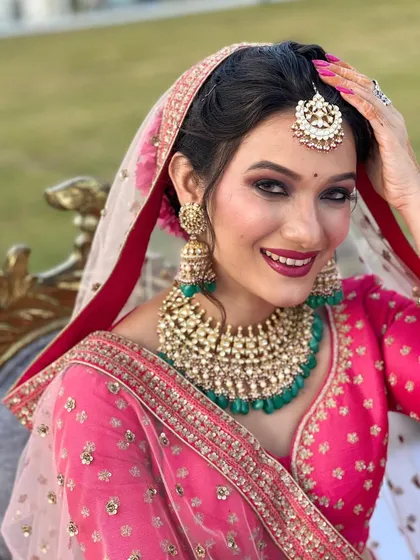 This is modern bridal glamour at its finest. For this North Indian wedding look, I focused on a flawless airbrush base, a striking smokey eye, and a bold lip to match the vibrant pink lehenga. The entire look is tied together with stunning Polki and emerald jewellery.