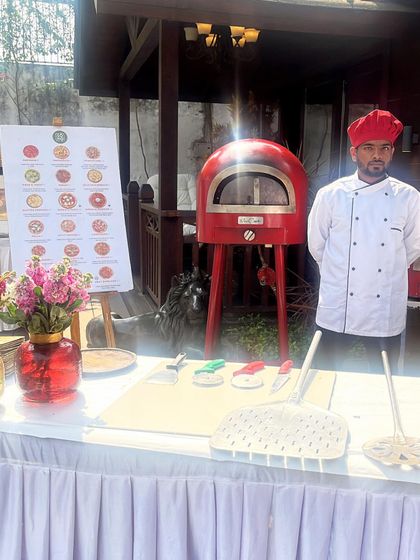 Here is my little red oven, the centerpiece of my catering setup. It's compact enough to fit in various locations but powerful enough to bake authentic wood-fired pizzas.